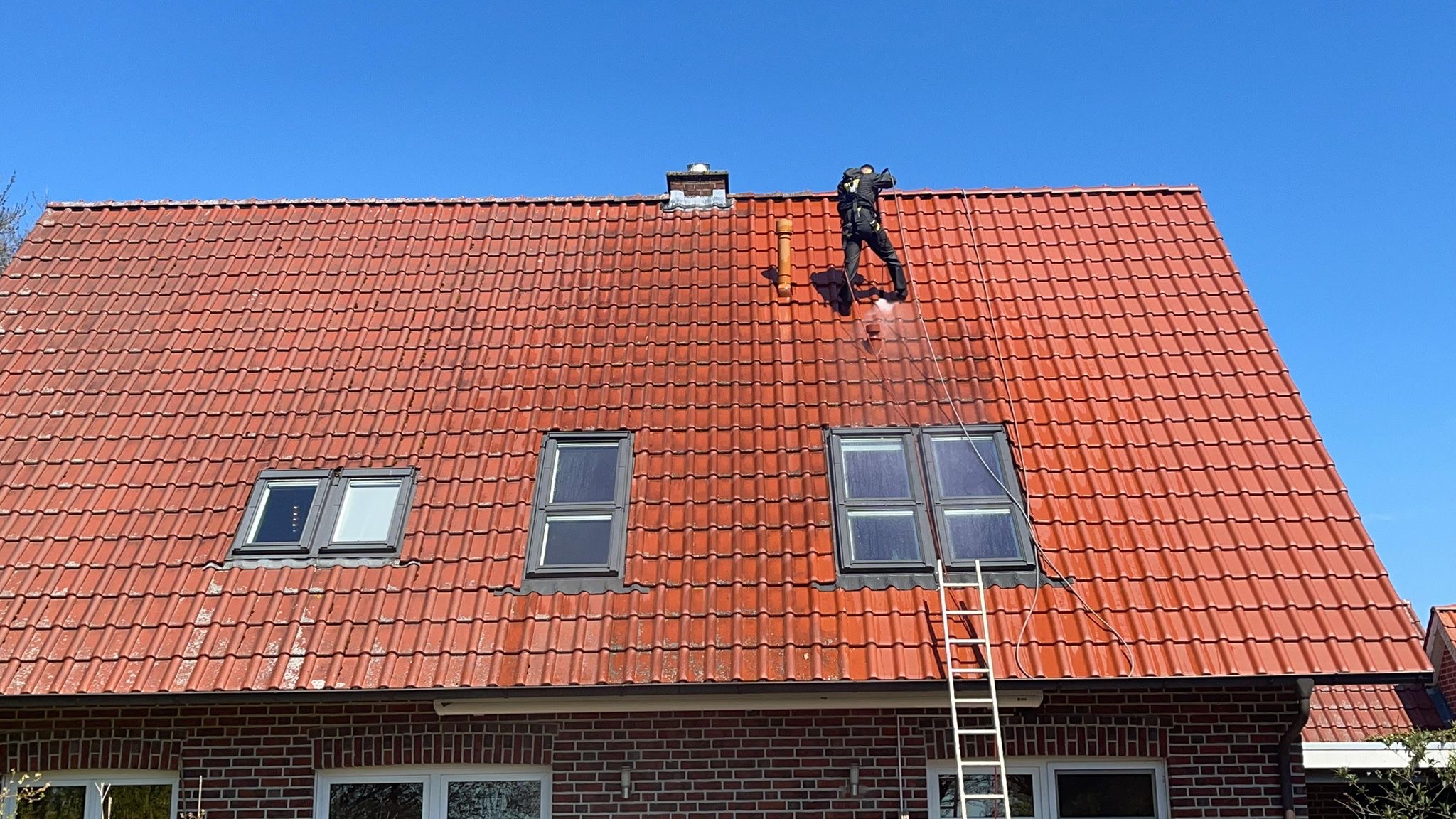 Reinigung einer Dachfläche während der Arbeit